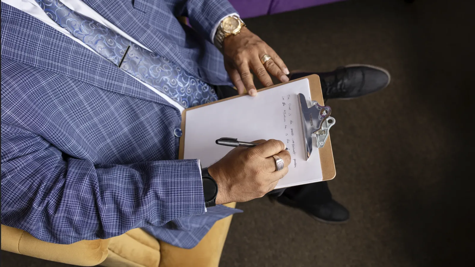 Counselor writing session notes on a clipboard
