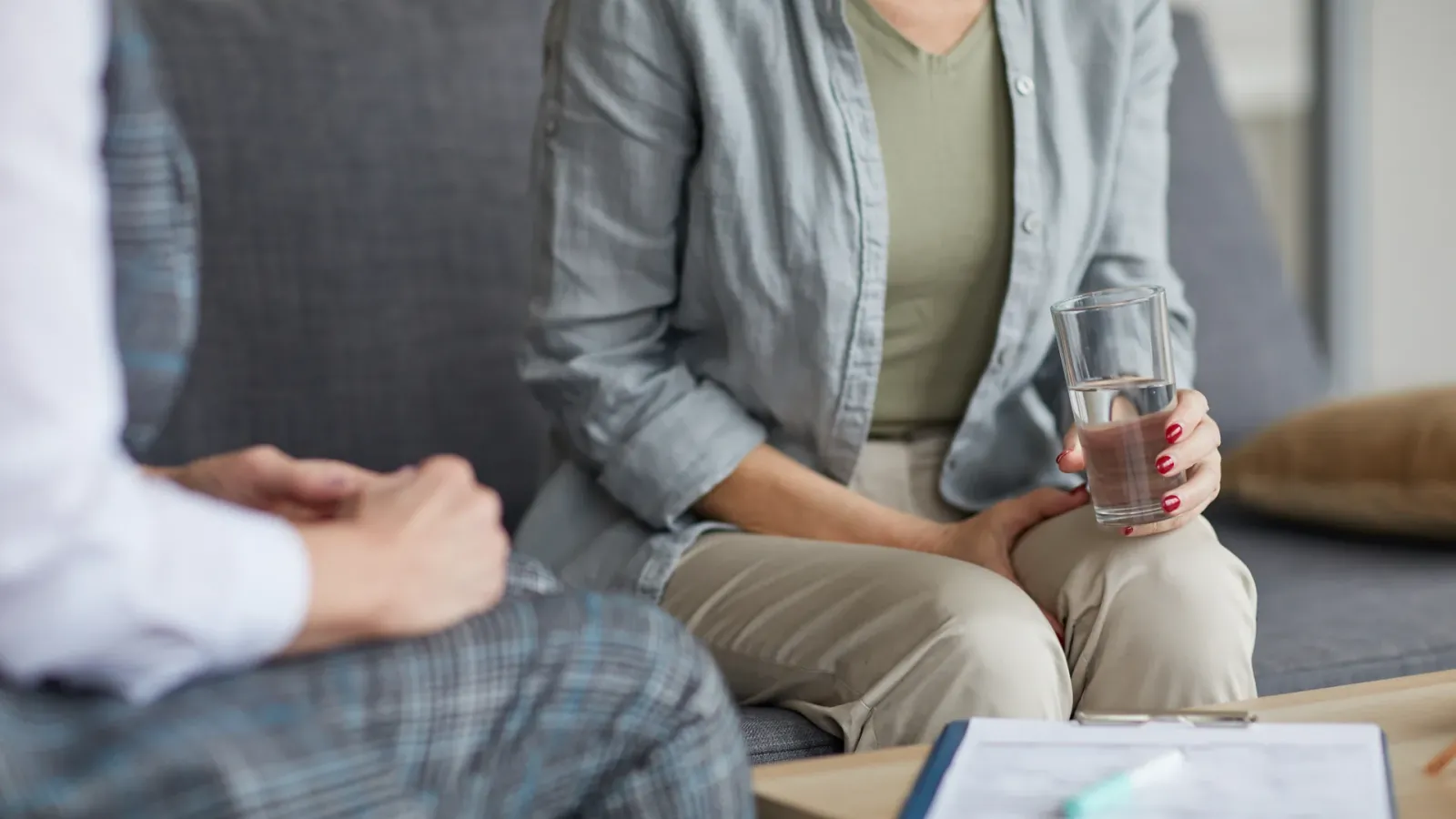 Client holding a glass of water during a grief counseling session